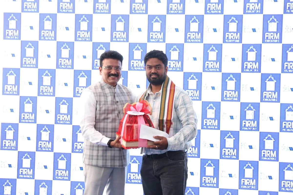 A Firm Foundations representative presents a gift to a Nexa Floors team member in front of a Firm Foundations backdrop