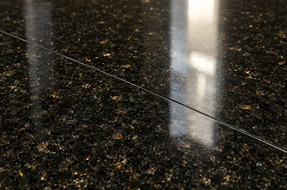 Close-up of a polished black granite floor with fine gold flecks