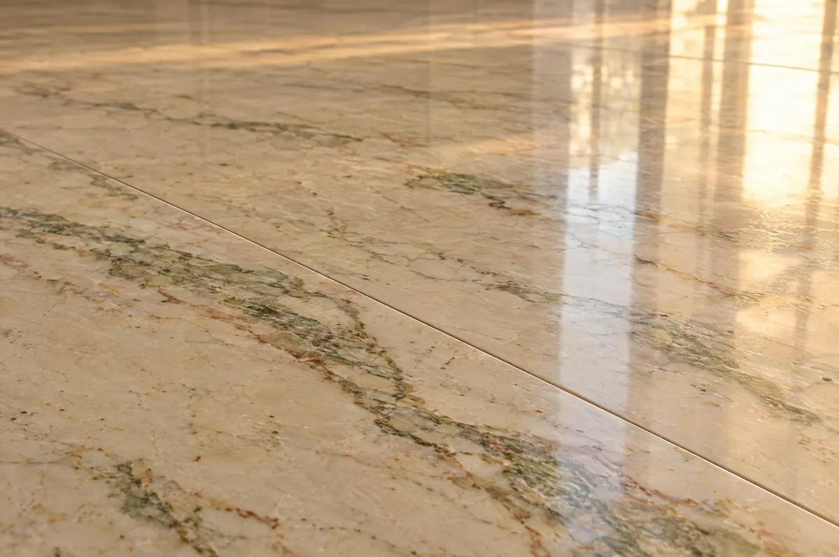 Close-up of a polished beige Indian marble floor with green and brown veining