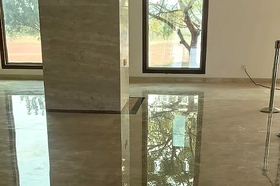 Polished Italian marble floor reflecting a window, a tree outside and a stone-clad pillar like a mirror