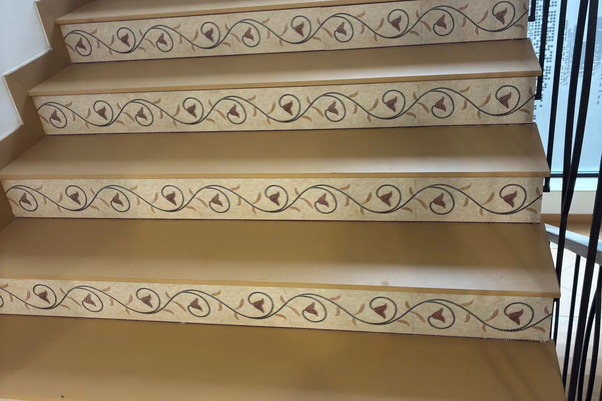 Finished staircase with beige treads and decorative floral-pattern risers