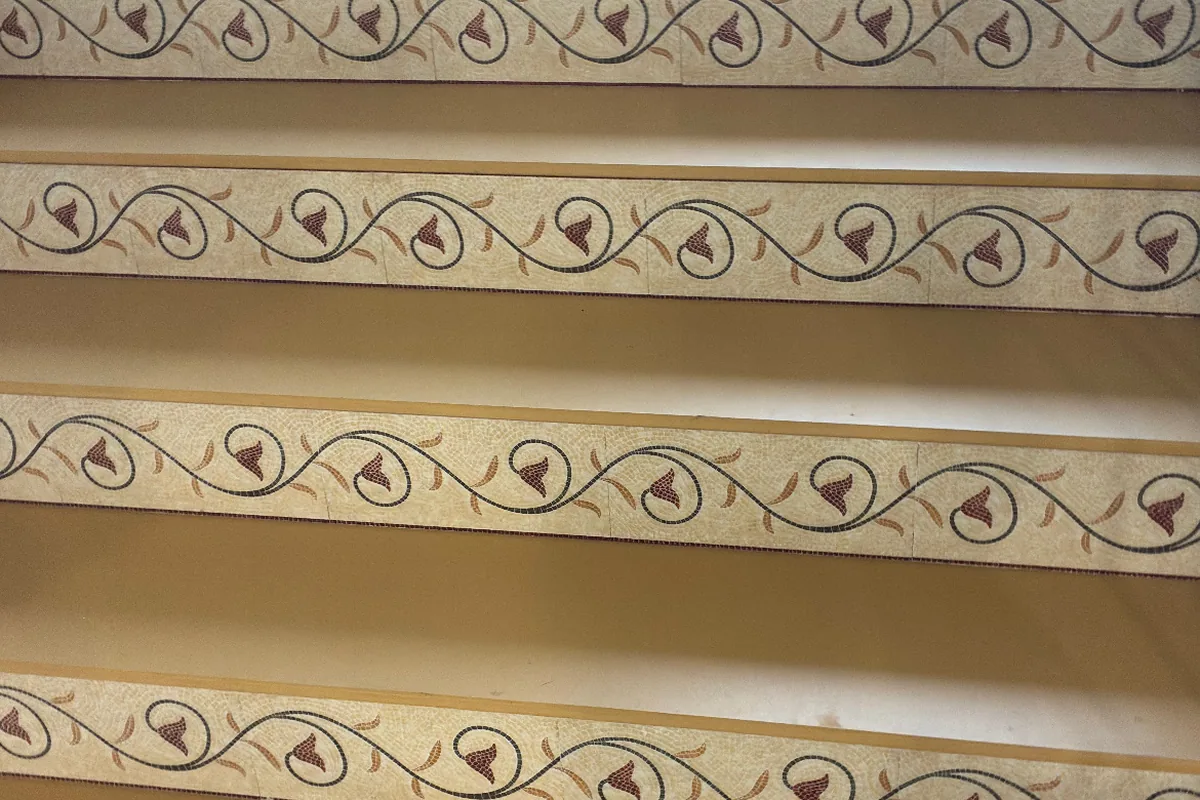 Finished staircase with beige treads and decorative floral-pattern risers